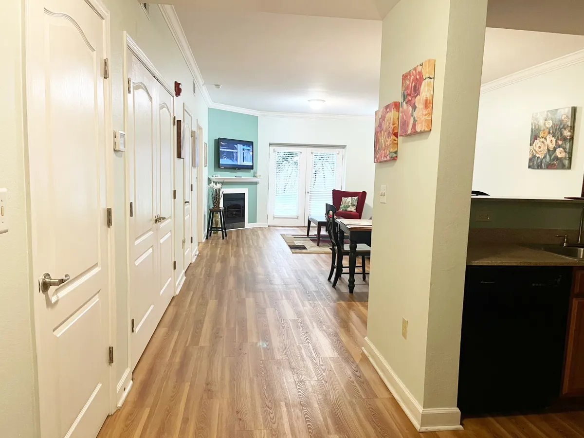 A welcoming dining area with wooden flooring, a cozy fireplace, and tasteful artwork on the walls. The spacious setup is ideal for families or groups to gather for shared meals, play games, or unwind together in a home-like environment.